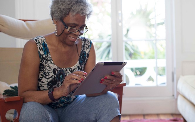 Senior Woman Using Digital Tablet Living Room