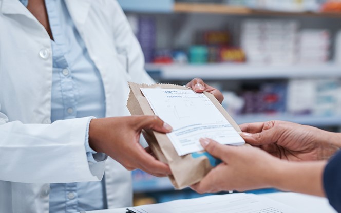 Pharmacist Giving Prescription Drug To Customer