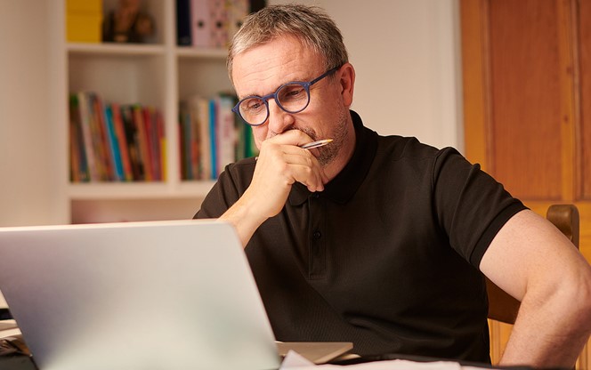 Mature Man Working On His Laptop From Home Looking Concerned