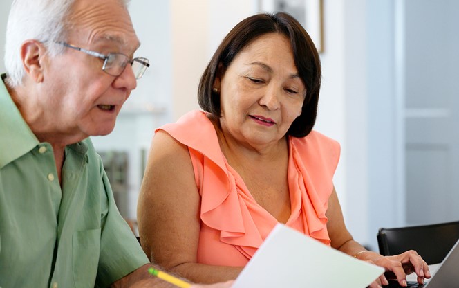 Hispanic Senior Couple Using Laptop To Organize Financial Planning