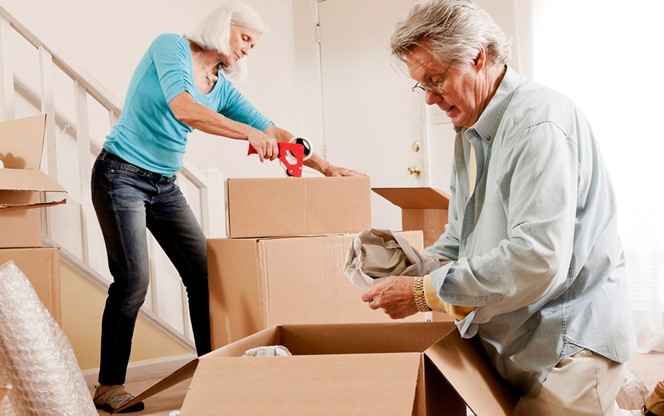 Senior Couple Boxing Their Furniture And Preparing For A Move