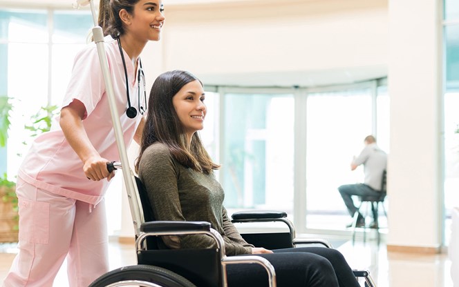 Nurse Assisting Patient In Wheelchair