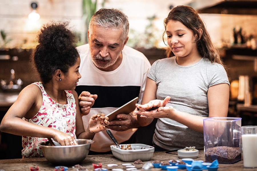 Grandfather Teaching Their Grandchild How To Prepare Brazilian Brigadeiro