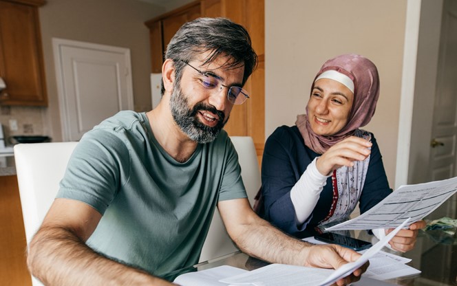 Arab Couple Smiling And Doing Their Finances