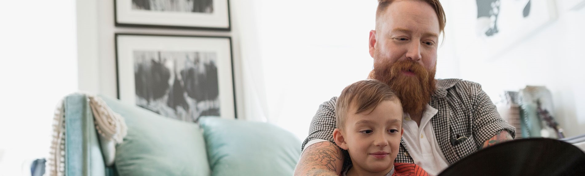 Father And Son Looking At Records On Living Room Floor