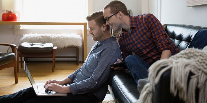 Couple Using Laptop In Living Room