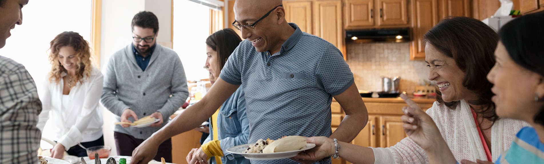 Latinx Family Enjoying Buffet Dinner In Kitchen