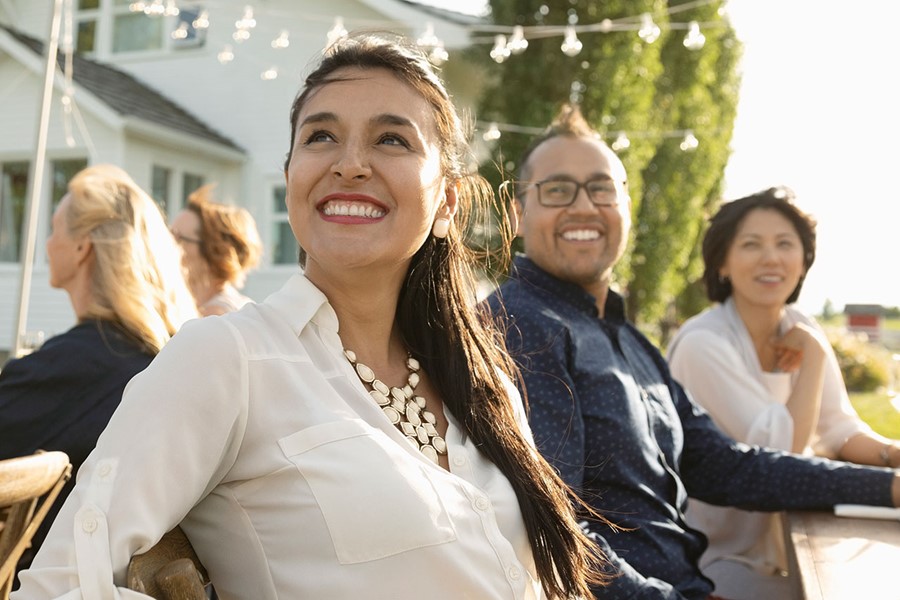 Smiling Woman Enjoying Garden Party At Sunny Patio Table