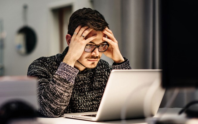 Young businessman holding his head and pondering