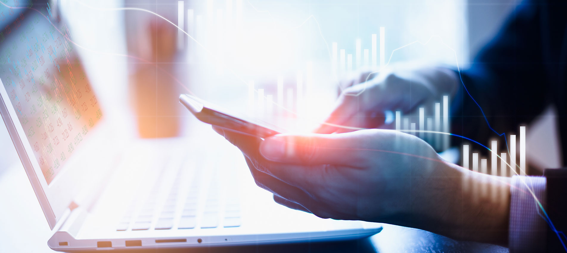 Man looking at his phone and laptop