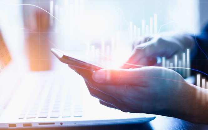 Cybersecurity Risk in Defined Contribution Plans Man looking at his phone and laptop