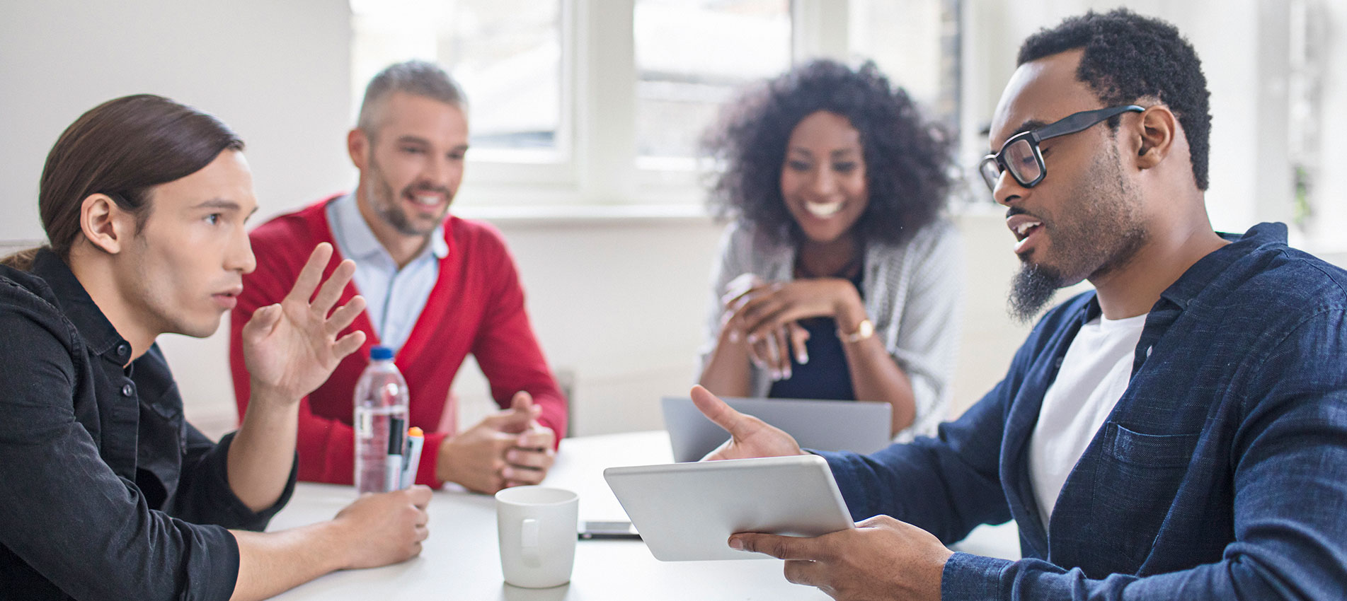 Multi-ethnic business people discussing over digital tablet