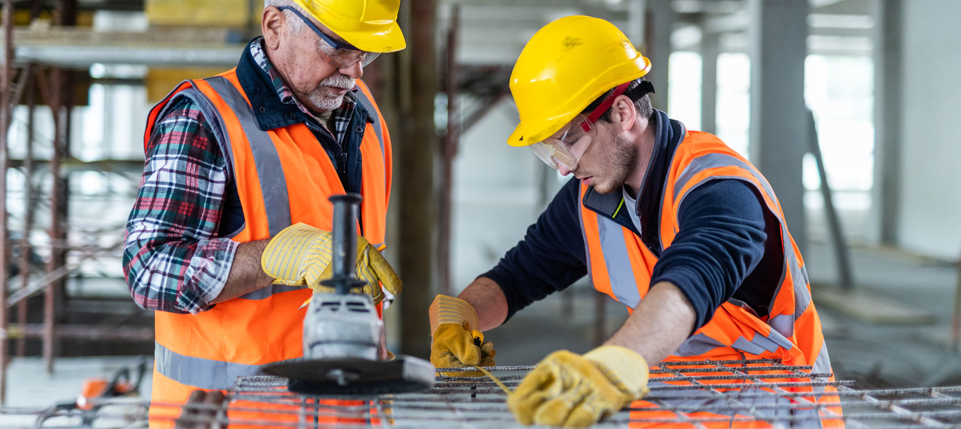 Construction Workers Measuring Iron Mesh