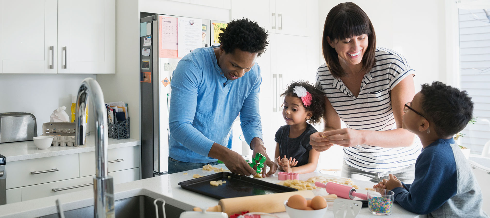 Family Baking Cookies In Kitchen