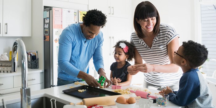Family Baking Cookies In Kitchen