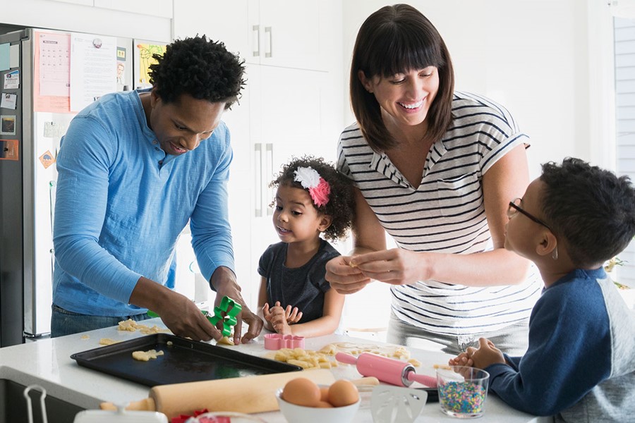 Family Baking Cookies In Kitchen