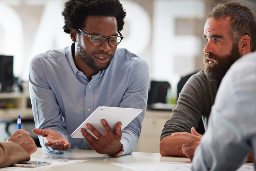 Businessman Presenting To Co Workers With Tablet