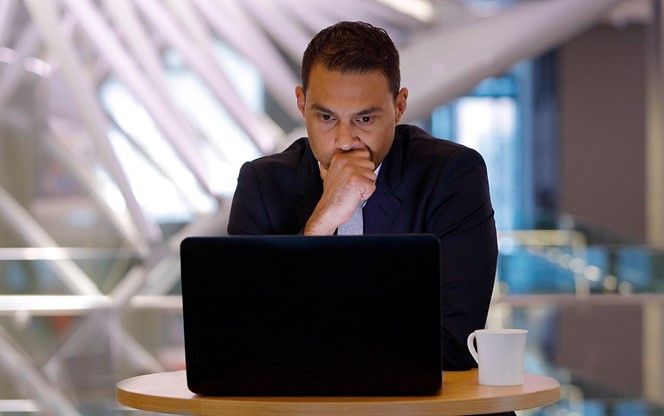 Serious businessman looking at a laptop