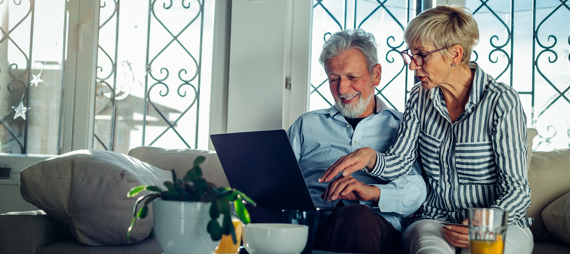 Old Couple Reading Emails From Their Kids