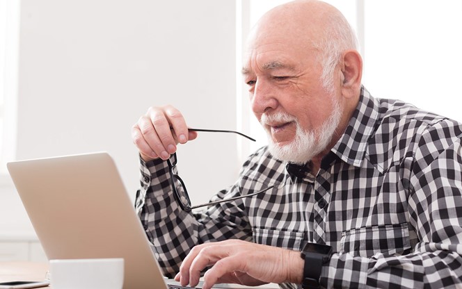 Smiling Senior Man Using Laptop Copy Space