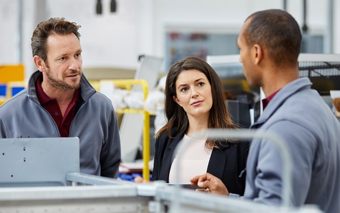 Engineers And Manager Discussing In Car Factory