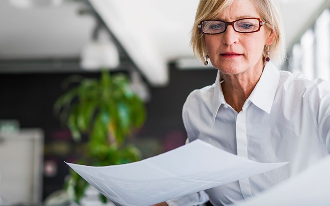 Businesswoman examining documents at desk