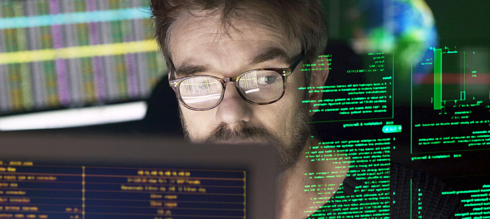 Stock close-up photo of a mature man surrounded by monitors & a holographic display which he is reading