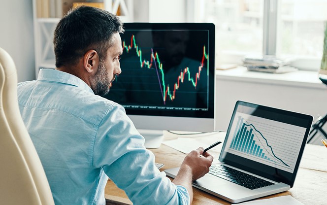 Man In Smart Casual Wear Analyzing Stock Market Data While Sitting In The Office