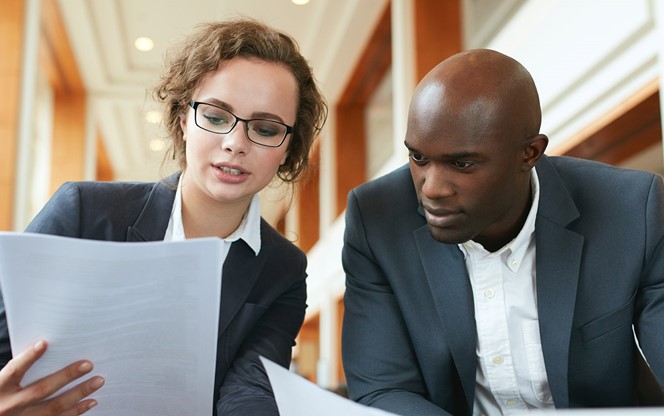 Two Business Partners Sitting In Cafe And Discussing Contract