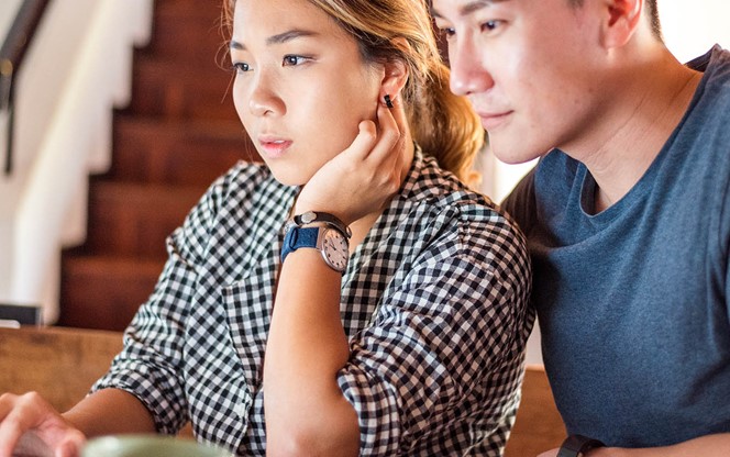 Young Asian Couple Using Laptop At Home