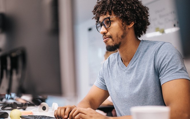 Young African American Programmer Working On Desktop PC In The Office