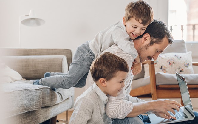 Father Trying To Work From Home With His Two Sons Are Playing Around Him