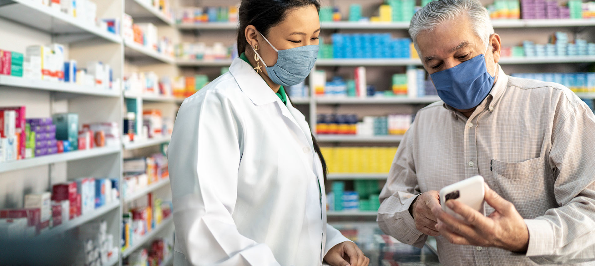 Female Pharmacist Helping Out A Male Senior With A Prescription At The Pharmacy
