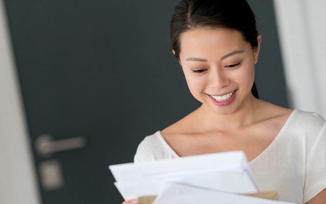 A Happy Asian Woman At Home Checking Her Mail