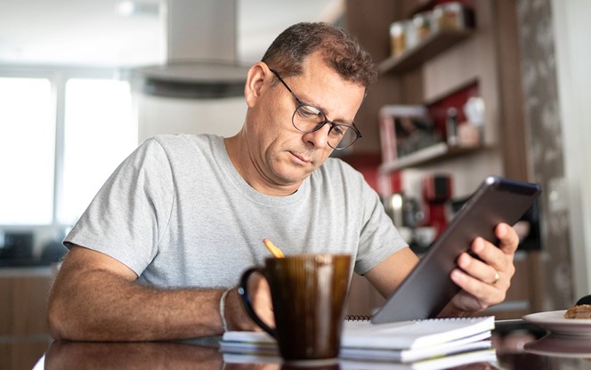 Man Taking Notes While Doing Home Office