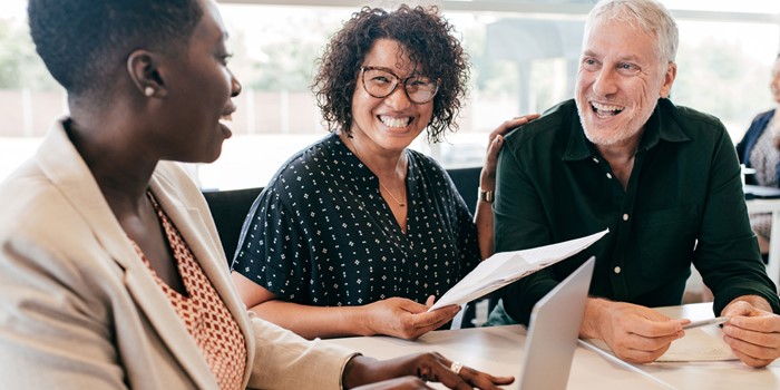 Three People At A Meeting Smiling
