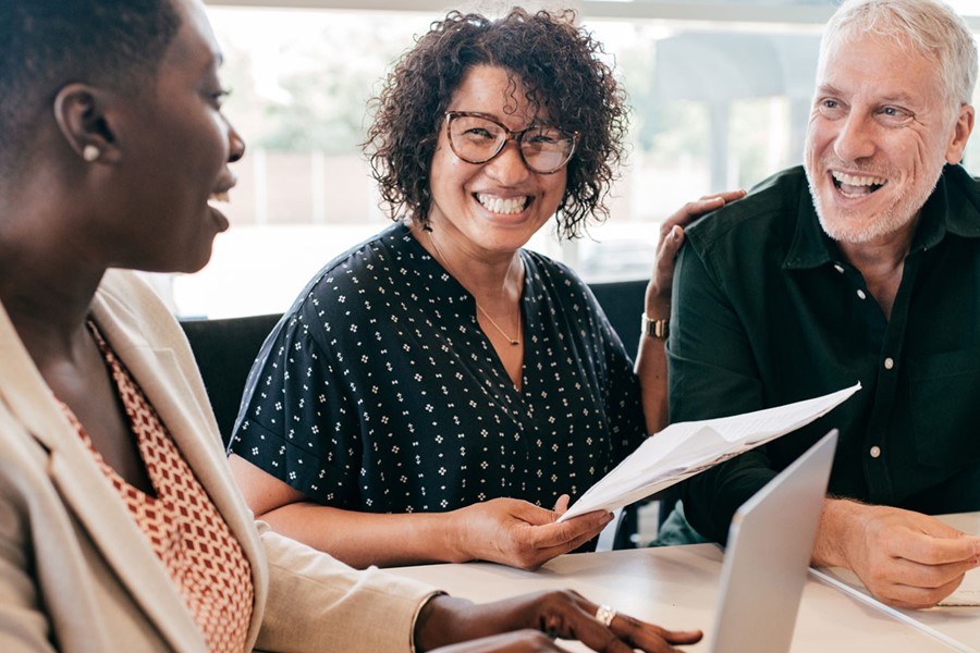 Three People At A Meeting Smiling