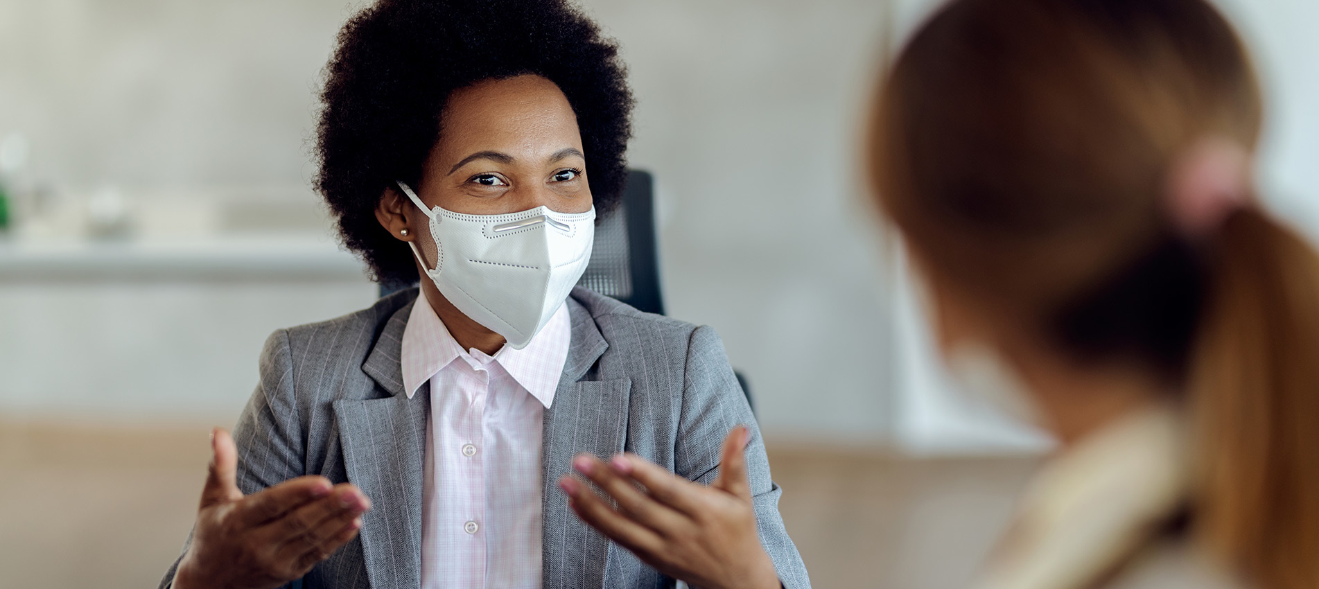 Black Female Financial Consultant Talking To Her Client And Wearing Protective Face Mask During The Meeting