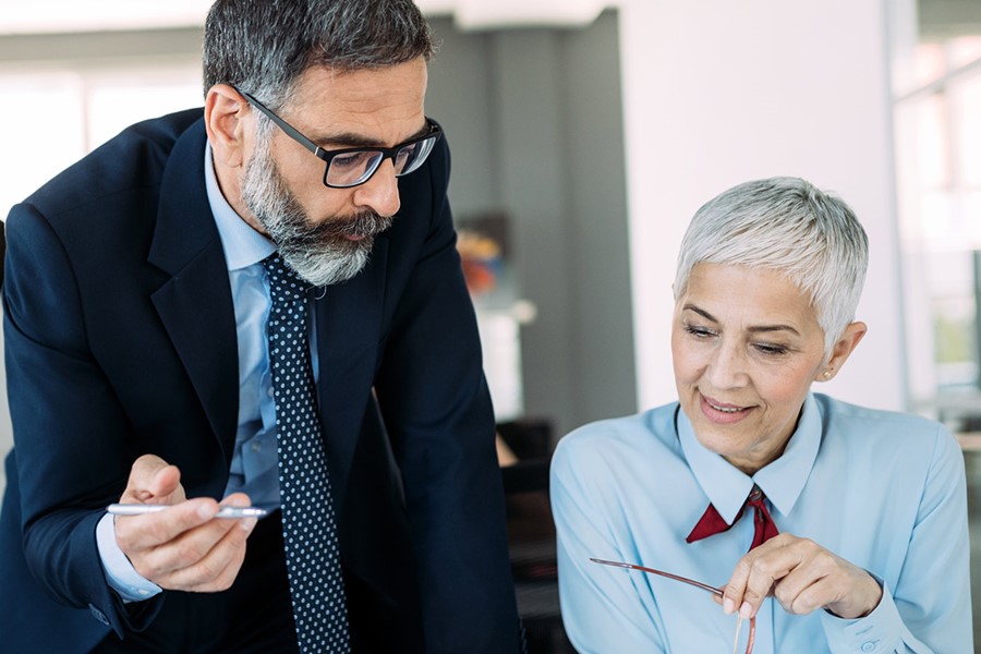 Mature Businessman And Businesswoman Planning In Office