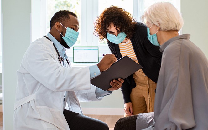 Senior Woman And Her Daughter Having A Doctors Appointment