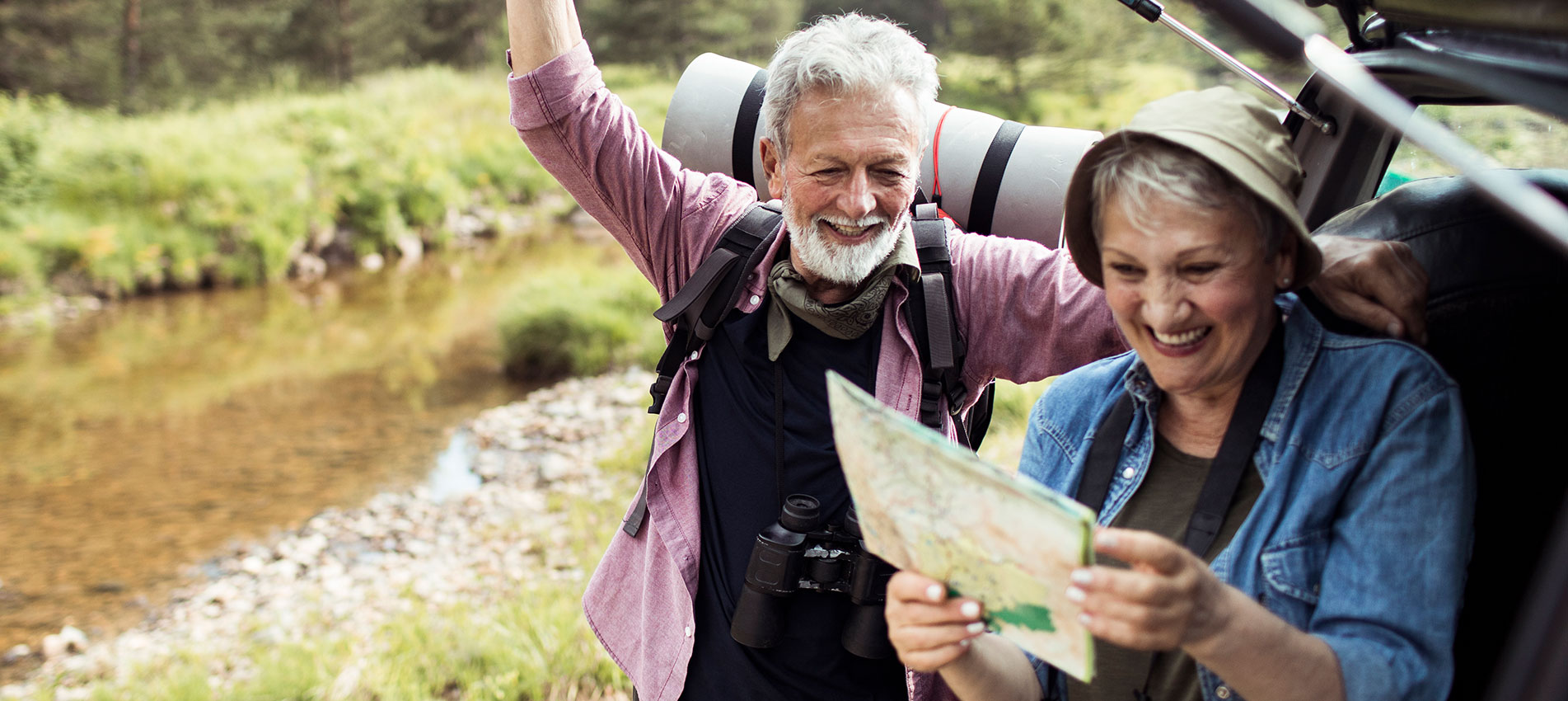 Senior Couple Grabbing Their Hiking Gear From The Car And Going Hiking