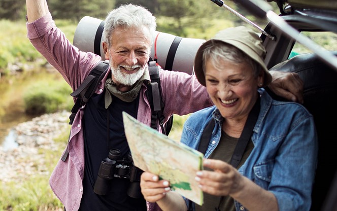 Senior Couple Grabbing Their Hiking Gear From The Car And Going Hiking