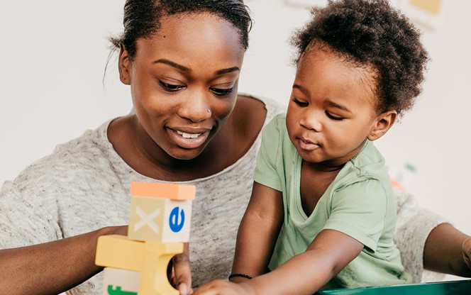 African American Mother With Toddler Playing With Educational Blocks