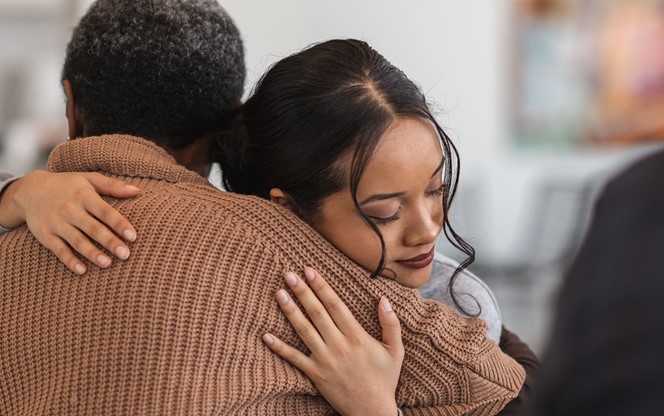 A Young Mixed Race Woman Hugs A Mature Adult Black Woman At A Group Therapy Session