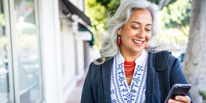 Mature Mexican Businesswoman Texting On Her Phone