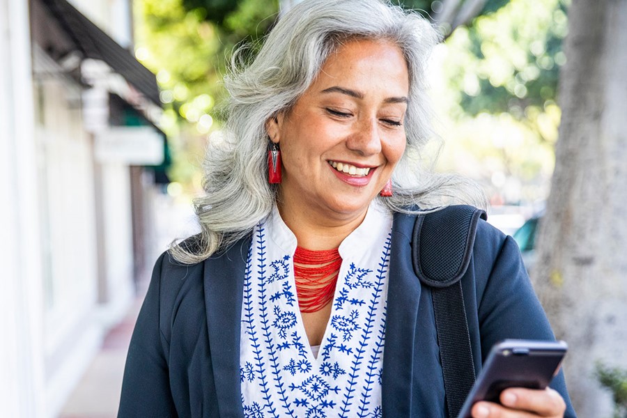 Mature Mexican Businesswoman Texting On Her Phone