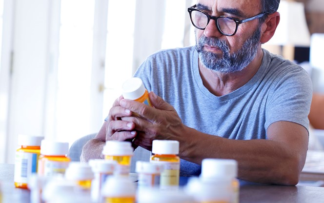 Man Sorting Through Prescription Medications