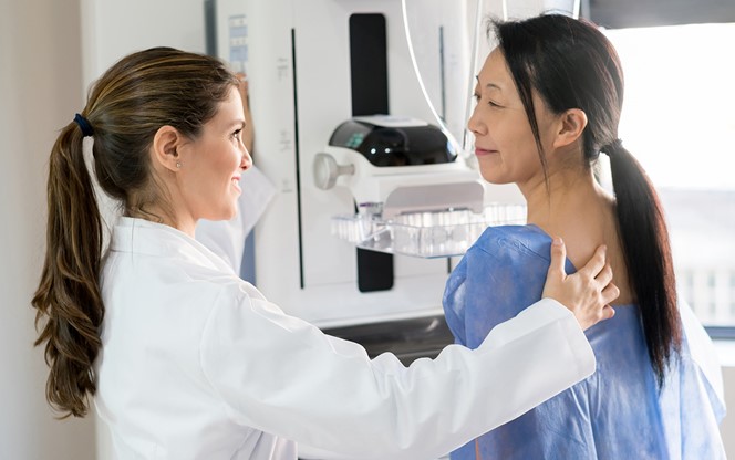 Technician Positioning Patient For Mammogram