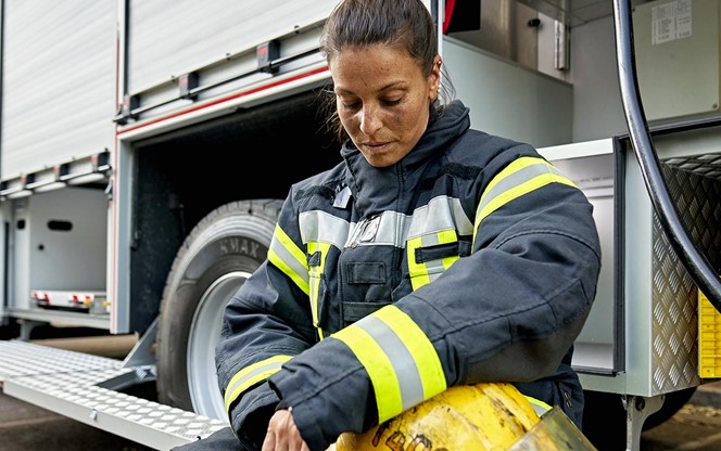Hispanic Female Firefighter Tired And Taking A Break