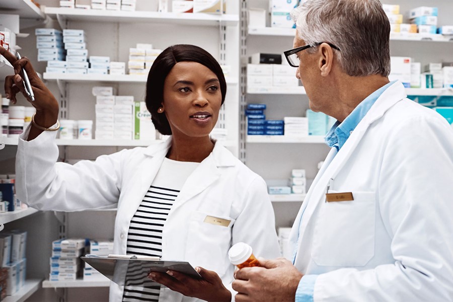 Two Pharmacists Working Together In A Drugstore